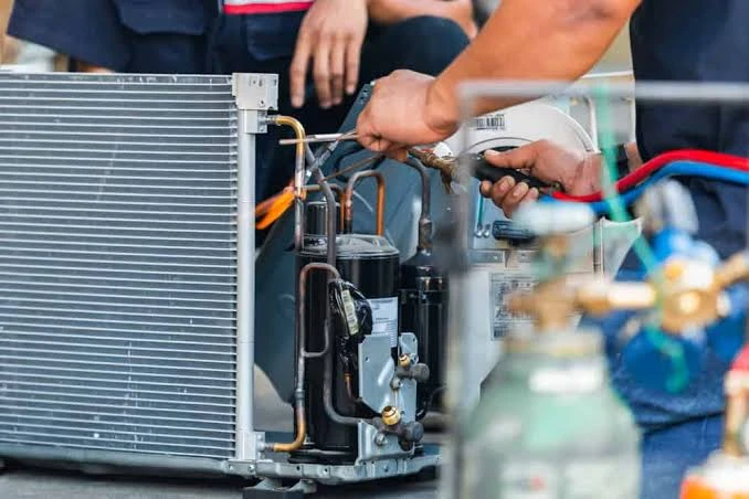 Illustrative close-up of an HVAC technician repairing refrigerant components