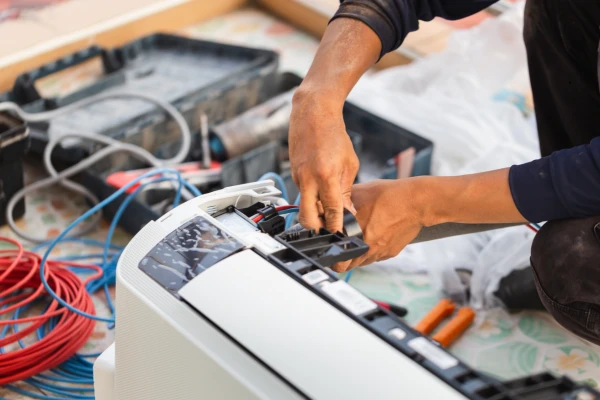 Illustrative technician servicing the controls and components of an indoor AC unit